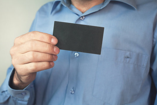 Businessman holding blank business card.