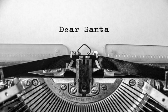 Dear Santa printed on an old vintage typewriter, close-up. Letter to Santa Claus with wishes for gifts, Christmas, New Year.