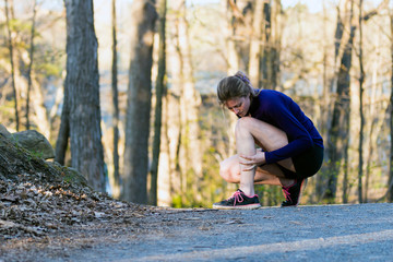 Shin splint running injury for young woman jogging on nature trail