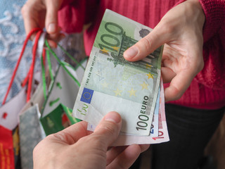 Customer pays euro bills cash while shopping. 
