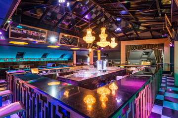 Interior design of discotheque with luxury chandeliers above bar counter - 181378635