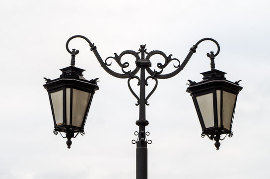 Close up of ornamental street lamp against cloudy gray sky