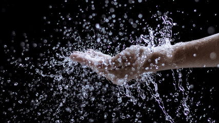 Hand mit Wasserspritzer
