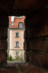 Windows in facade of old building framed by hole in brick wall cloudy day, Warsaw Poland
