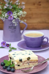 Tiramisu mit Heidelbeeren auf einem Teller Tischdekoration in Lila