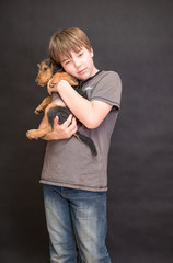 Happy boy portrait, boy and dog in love. Friends having fun whilst posing. Young little cute adorable kid and his puppy, obstreperous scamps. Poses, face expressions, ease, black background