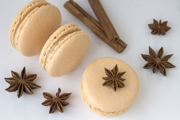 Sweet macarons, spices anise and cinnamon sticks on white background
