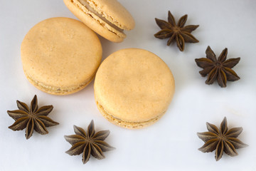 Sweet macarons, spices anise and cinnamon sticks on white background