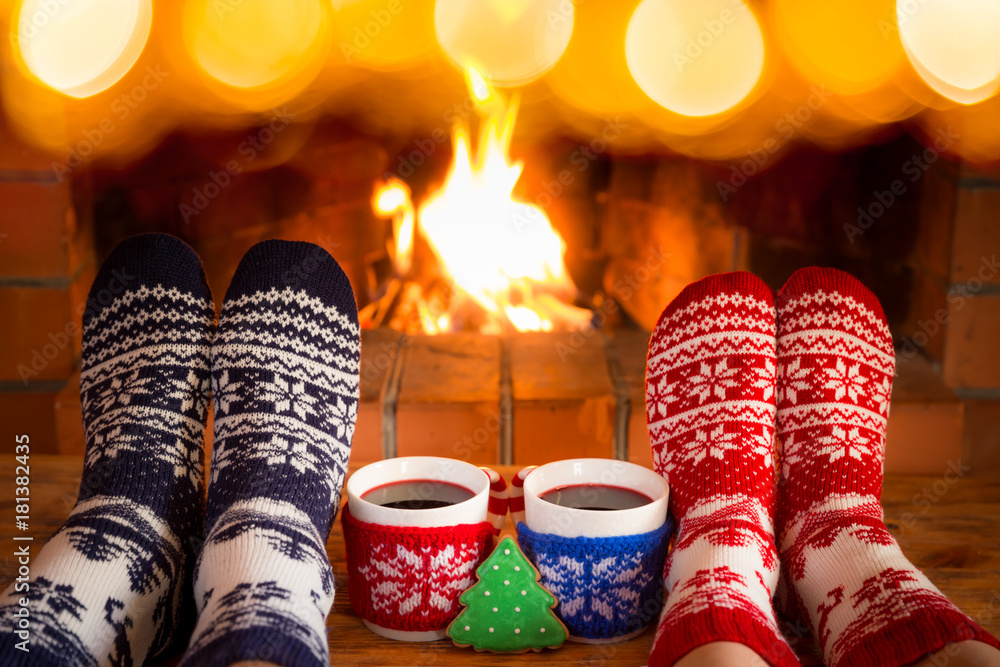 Poster Couple in Christmas socks near fireplace