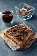 Board with delicious toast and chocolate paste on table