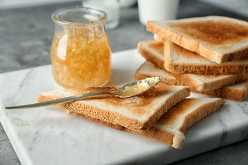 Board with tasty sweet toasts and jam on table