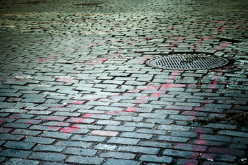 Old New York City cobblestone street with manhole cover texture