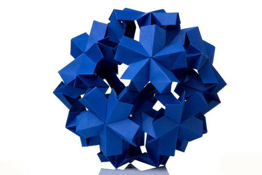 Blue flower isolated on white. Cool paper folding project. Floral origami decoration, result of arts lesson at the school.