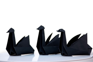 Composition of three black swans on white background. Elegant origami figurines, traditional style.