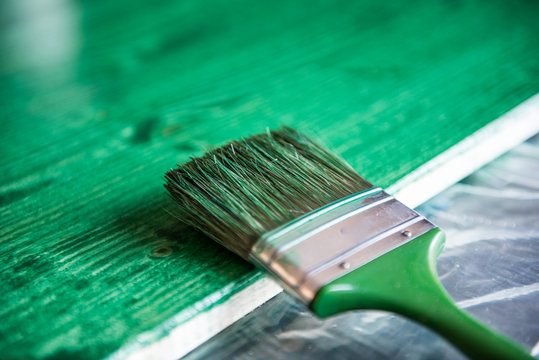 Painting brush on green wooden background
