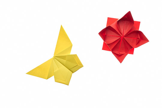 Yellow butterfly and red flower on white. Simple origami models, folding paper art. Hand crafting for children.