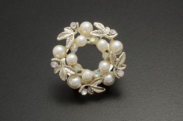 gold round brooch with pearls isolated on a black background