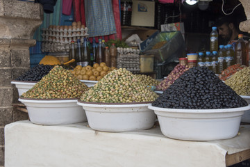 Large bowls of Green, black  and Pink Olives for sale in a Moroccan Market	