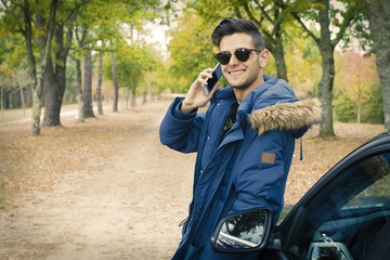 young adult with car and outdoor mobile phone