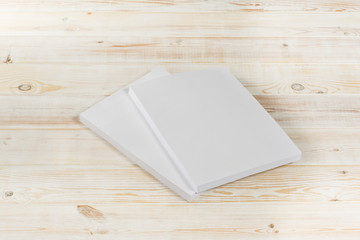 Fototapeta premium Mockup of magazine, poster, A4 brochure, catalog or flyer isolated on white wooden background. Blank page top view for use in design, mockups and simulations.