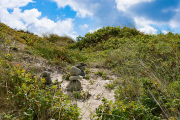 Steinturm auf Düne zwischen Sand und Dünengras als Querformat