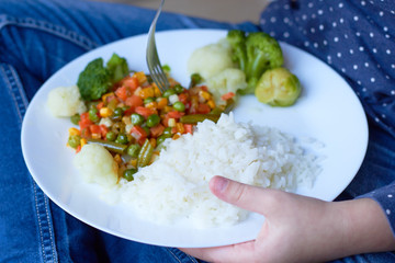  Delicious and healthy lunch for the child. Fried vegetables with rice on a plate
