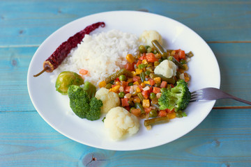 fried vegetables and rice on a white plate