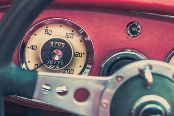 Close-up, detailed photo of the interior, dashboard and speedometer of a classic oldtimer car.