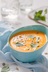 Roasted pumpkin and carrot soup with cream and pumpkin seeds