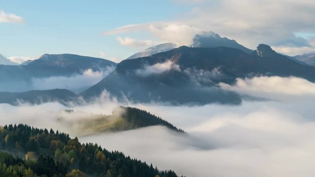 Foggy morning with wave of clouds in mountains valley landscape time lapse
