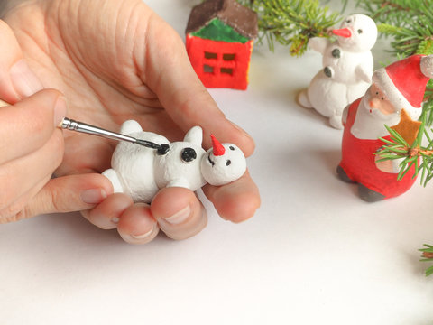 Handmade manufacture of a small toy snowman. Preparations for the celebration of Christmas.
