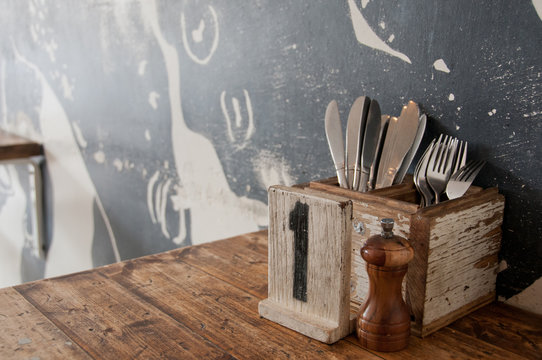 Silver knift fork pepper on a wooden classic table in a restaurant