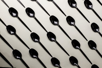 black plastic spoons on a gray background