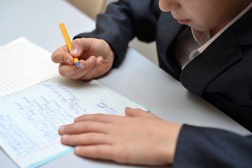 Selective focus of little boy learning how to write his name, Kid study at home, Children do homework at home, Concept for toddler learn about writing the letter or message © andov