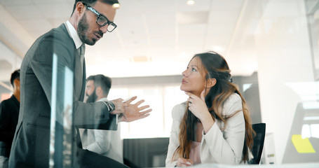 Picture of businessman and businesswoman talking in office