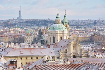 Winter Prague panorama with St. Nicholas church, roofs of Lesser Town, Old Town and TV Tower