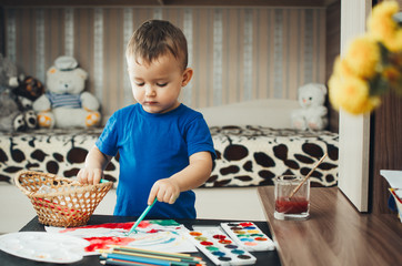 the baby in the nursery, with enthusiasm draws paints © komokvm