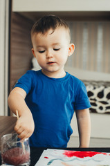 the baby in the nursery, with enthusiasm draws paints