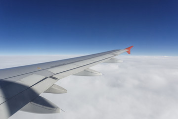 cloudy sky with wing of airplane view from illuminator