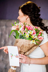 Happy bride in white dress with a bouquet in hand