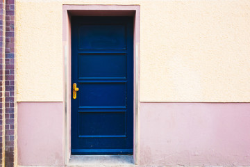 Obraz na płótnie Canvas blue entrance door on orange building