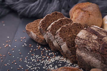 Assortment of baked bread on dark background.