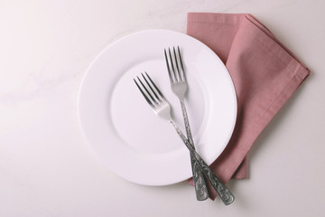Food background. White empty plate, cutlery, napkin. Top view, copyspace.
