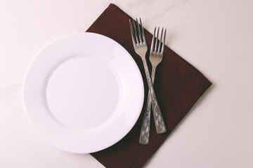 Food background. White empty plate, cutlery, napkin. Top view, copyspace.