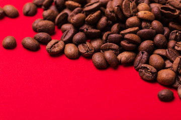 Roasted coffee beans on red background. Color surge trend.