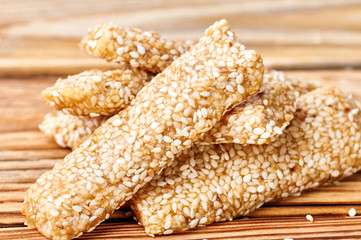 Eastern sweetness from sesame seeds on a wooden background. Appetizing healthy bar for athletes, for people on a diet. Candy made of sesame, honey and butter.