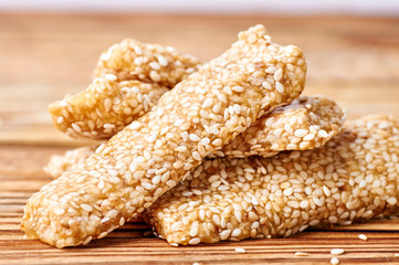 Eastern sweetness from sesame seeds on a wooden background. Appetizing healthy bar for athletes, for people on a diet. Candy made of sesame, honey and butter.