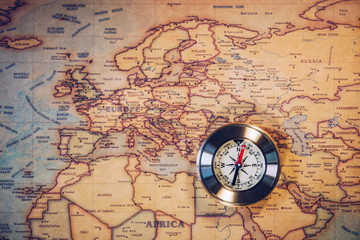 Fototapeta na wymiar Old compass on vintage map. Adventure stories background. Retro style. The map used for background is in Public domain. 