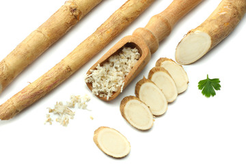 sliced horseradish root with parsley isolated on white background