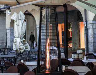 heating lamp placed among the tables of an open cafe